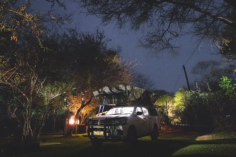 Camping bei Nacht mit einem 4x4-Geländewagen zum Selbstfahren mit Dachzelt