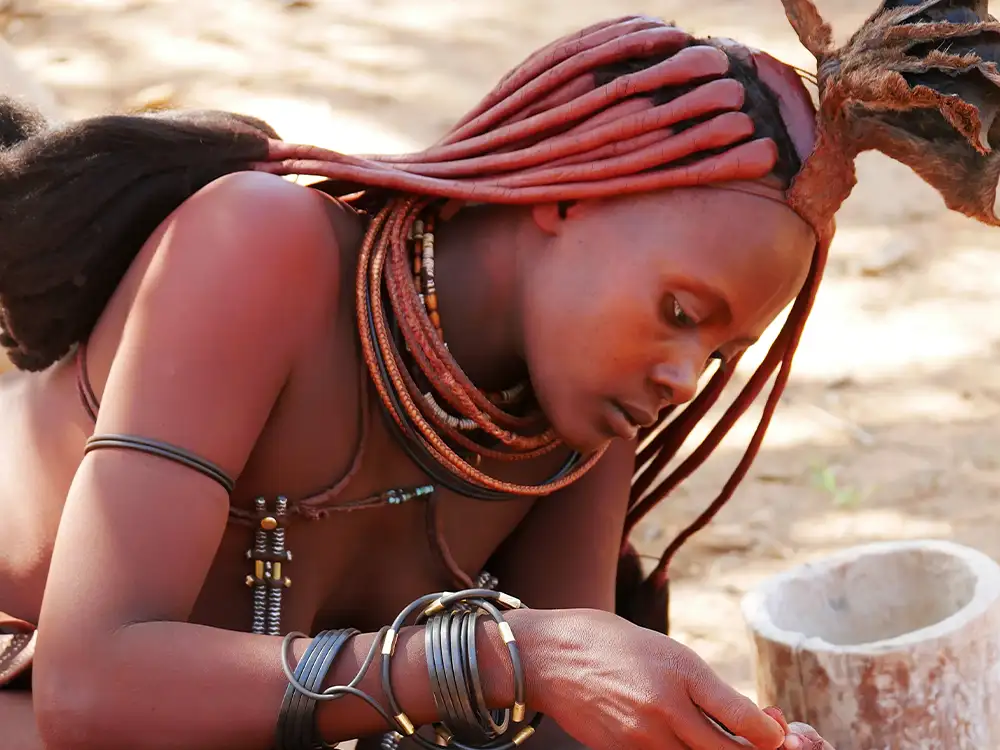 Himba in Namibia bei der Zubereitung von Essen Himba in Namibia bei der Zubereitung von Essen