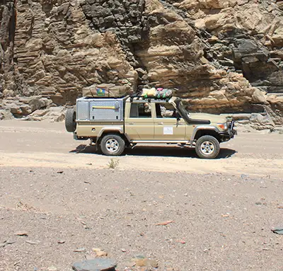 Geländewagen fährt durch die Wüste Namibias Geländewagen fährt durch die Wüste Namibias