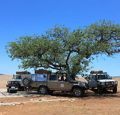 4×4-Fahrzeuge fahren im Konvoi durch die Landschaft Namibias mit dem Auto durch die Landschaft Namibias fahren